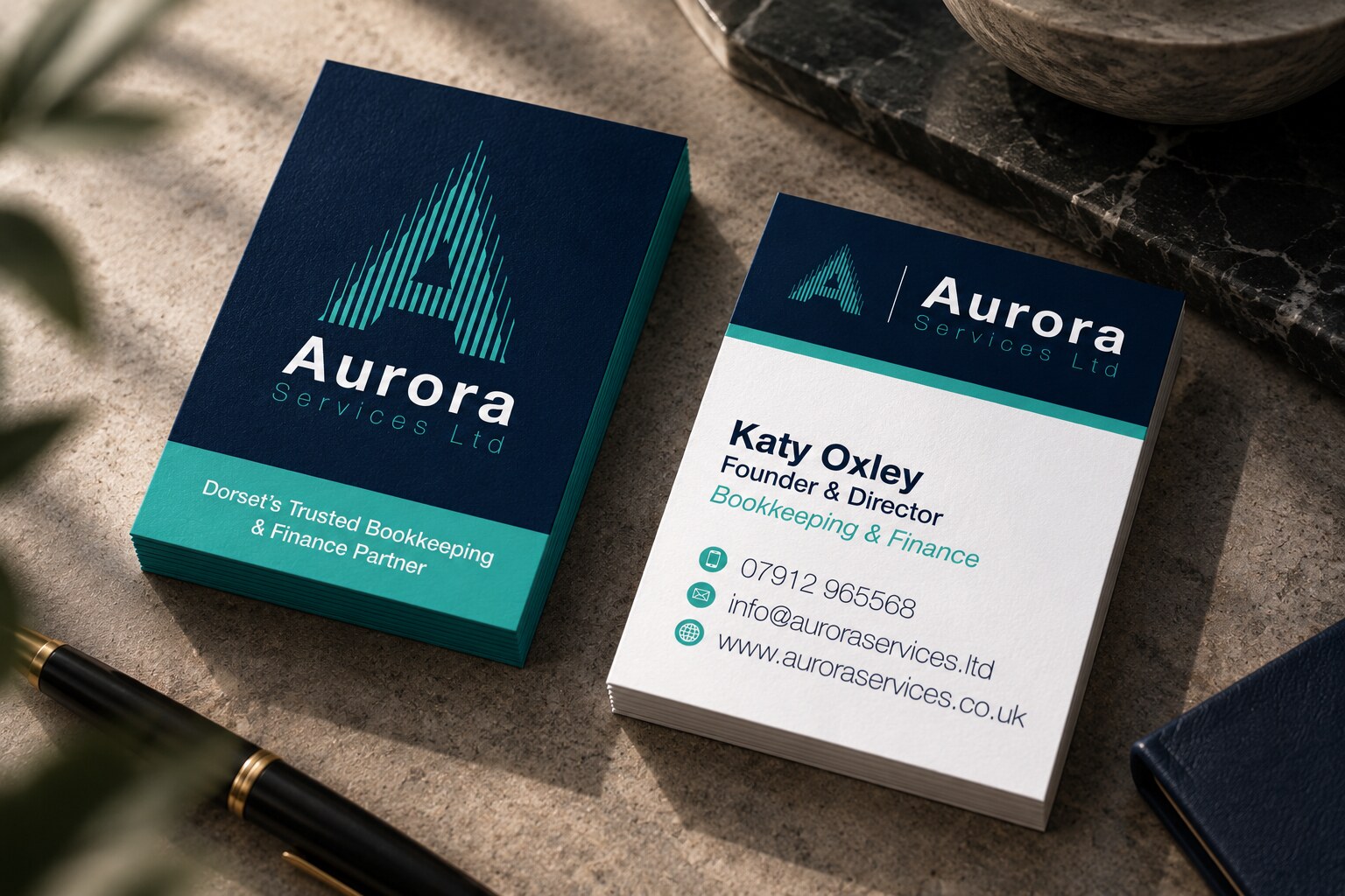 Aurora Services business cards in navy and teal